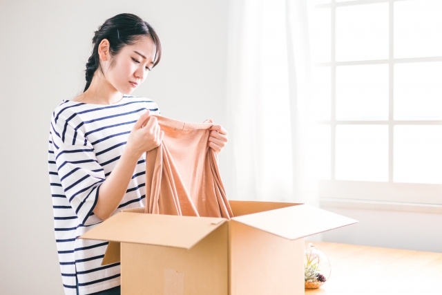 通販で購入した服を開封する女性の写真